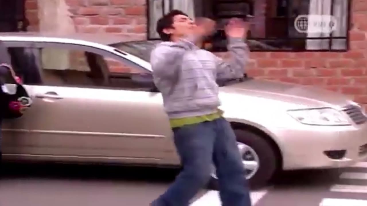 Un hombre esquiva un auto en una calle de ladrillo