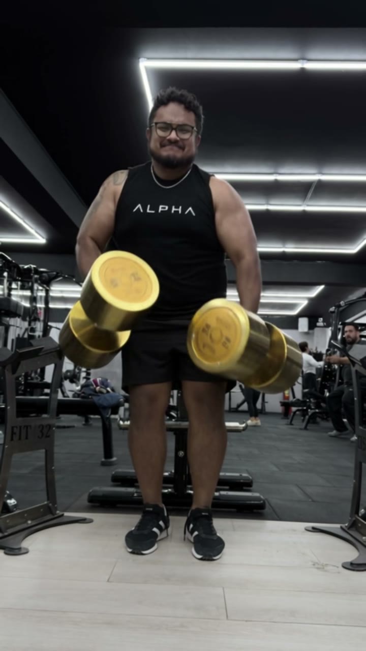Carlos entrenando con mancuernas en un gimnasio